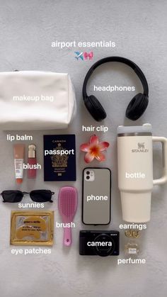 the contents of a travel bag laid out on top of a white surface with headphones, hairbrushes, and other items