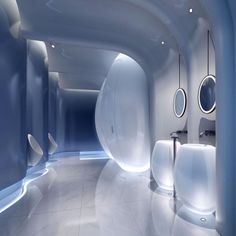 an empty bathroom with blue walls and white fixtures on the wall, along with round mirrors