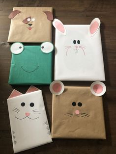 four paper bags with faces and ears on them sitting on a wooden floor next to each other