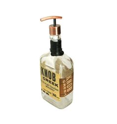 a hand soap dispenser with an orange and brown label on the front