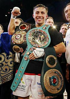 two men standing next to each other with their fists raised in the air and wearing boxing gear