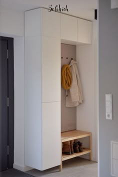 an open closet with shoes and coat hanging on the wall next to it in a bedroom