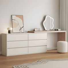 a white dresser sitting on top of a wooden floor next to a mirror and lamp