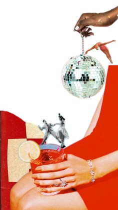 a woman holding a drink in her hand and disco ball hanging from the ceiling above her head