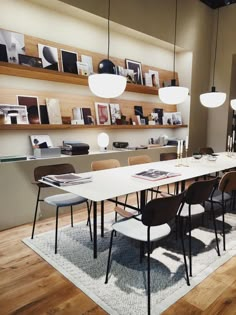 a dining room table with chairs and pictures on the wall in the backround