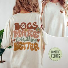 a woman wearing a t - shirt that says dogs make everything better with flowers on it