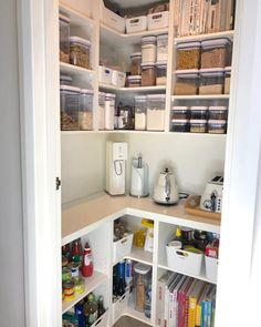 an organized pantry with white shelving and lots of food in the bins on the shelves