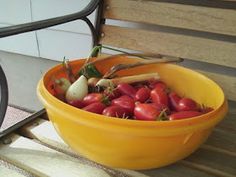 a yellow bowl filled with vegetables sitting on top of a wooden table next to stairs