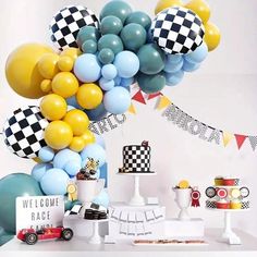 a table topped with balloons and cake next to a sign that says welcome home race