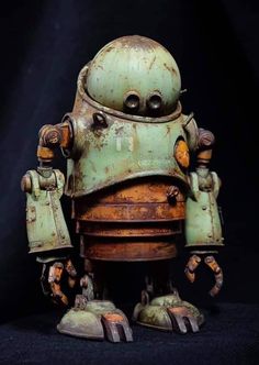 an old, rusty robot is sitting on a black surface