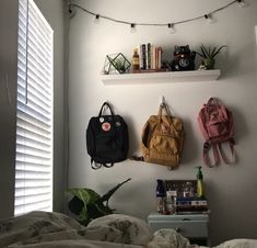 three purses are hanging on the wall above a bed