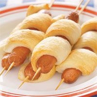 hotdogs wrapped in bread on a plate with toothpicks sticking out of them