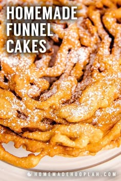 a pile of powdered sugar covered pretzels on a white plate next to a fork