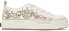 Low-top cotton canvas sneakers in off-white. · Buffed leather trim throughout · Rubber cap toe · Lace-up closure · Logo flag at tongue · Gold-tone glittered graphic appliqués at sides · Pull-loop at heel collar · Buffed leather lining · Treaded rubber sole Supplier color: Gold Shoes Wishlist, Pretty Sneakers, Gold Glitter Stars, Trendy Shoes Sneakers, Shoe Wishlist, Gold Sneakers, Random Pict, Super Rich, Rich Kids