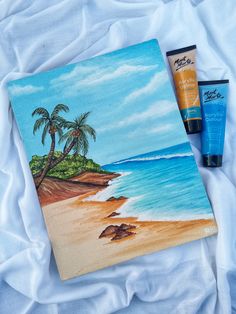 the painting is next to two tubes of sunscreen