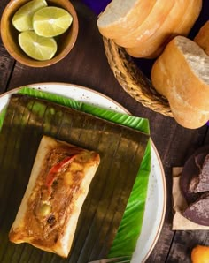 a plate with some food on top of it next to bread and other foodstuffs