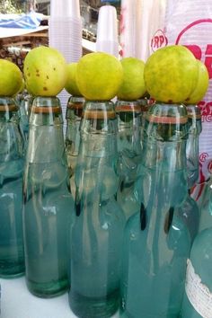 several green glass bottles with limes on top