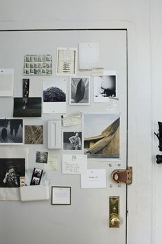 a white refrigerator covered in pictures and magnets next to a wall with a clock on it