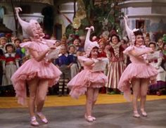 three ballerinas are performing in front of a crowd