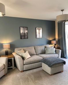 a living room filled with furniture and two lamps on either side of the couches