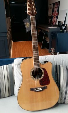 an acoustic guitar sitting on top of a couch