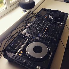 a dj's turntable sitting on top of a counter next to a window