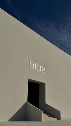 a white building with the word dior on it's side and stairs leading up to an entrance