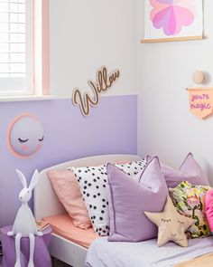 a child's bedroom decorated in pastel colors with pink, purple and white accents