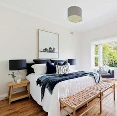 a bedroom with white walls and wood floors