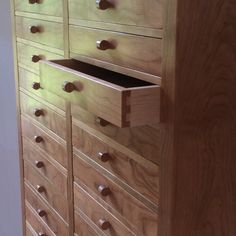 a wooden dresser with many drawers and knobs