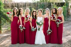 a group of women in red dresses standing next to each other