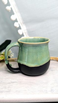 a green and black mug sitting on top of a counter