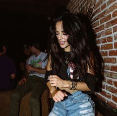 a woman is smiling while looking at her cell phone