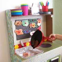 a young child is playing with a toy kitchen