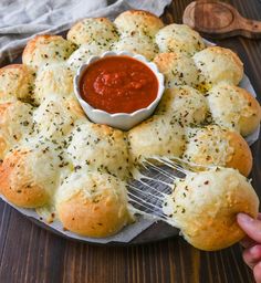 a plate filled with rolls and dipping sauce