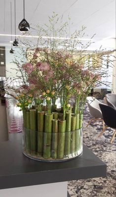 a vase filled with lots of flowers on top of a table