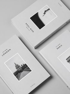 three white books with black and white photos on the front, back and side covers