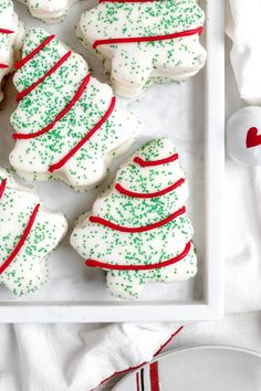 christmas sugar cookies decorated with green and red sprinkles on a white plate