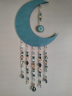 a blue crescent with beads hanging from it's side and a clock on the wall