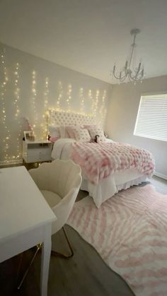 a bedroom decorated in pink and white with lights on the wall