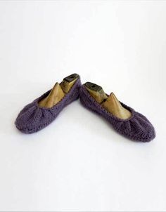 two pairs of purple slippers sitting on top of a white floor next to each other