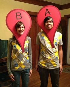 two people standing in front of each other with heart shaped signs on their heads that spell out the letters ba