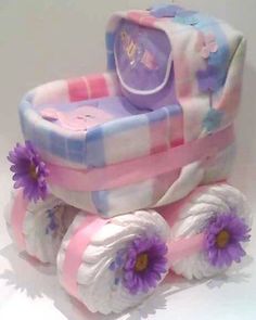 a cake shaped like a baby carriage with purple flowers on the front and bottom wheels