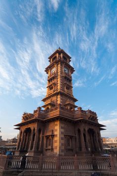 a tall tower with a clock on the top is in front of a blue sky