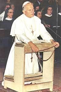 a man sitting at a podium in front of a crowd