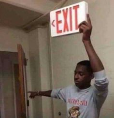 a man holding up a sign that says exit