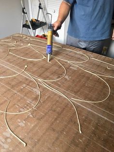 a man is using a drill to cut out the wire on top of a cardboard box