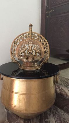 a gold and black container sitting on top of a marble floor