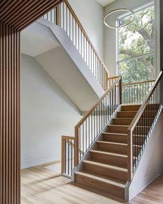 modern home staircase with white oak railings, hardwood flooring and a slat wood wall and ceiling design Slat Wall Entryway, Open Stairs In Living Room, Stairwell Design, Scandinavian Flooring, Acoustic Slat Wood Wall Panels, Wall Entryway, Metal Stair Railing, Stair Rails, Moore House