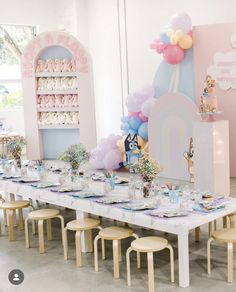 a table set up for a birthday party with lots of balloons and decorations on it